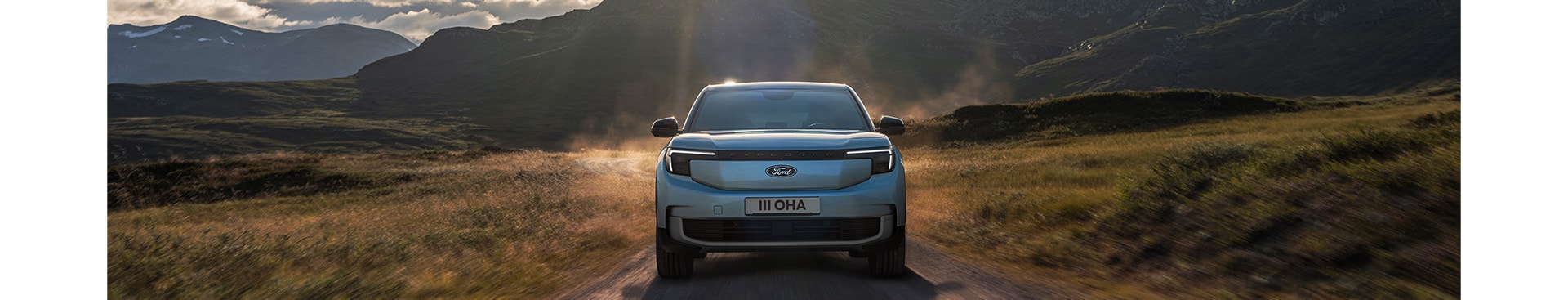 A woman charging a Ford electric car at a public EV charging station.