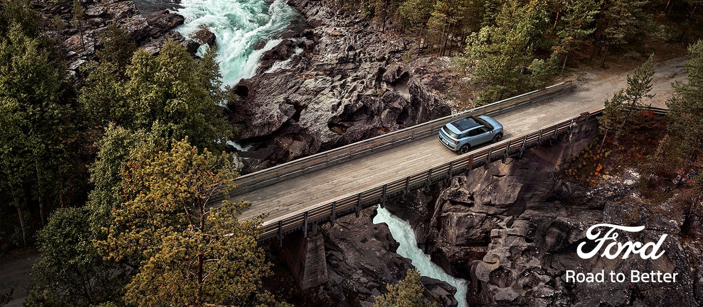 New Ford Explorer® driving over a bridge in the wild