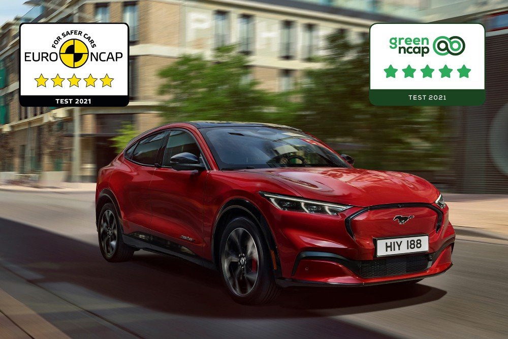 Punainen Mustang Mach-E ajaa tiellä, ja kuvan päällä on NCAP-turvallisuuspalkintojen logot.