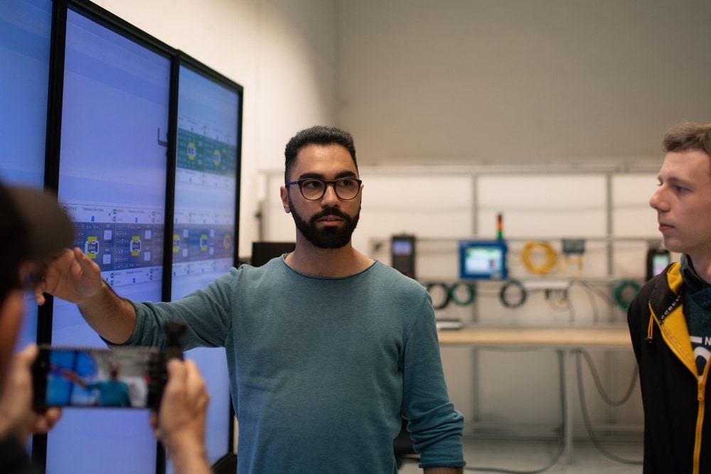 Ryhmä Fordin työntekijöitä pitämässä palaveria digitaalisen näytön äärellä.
