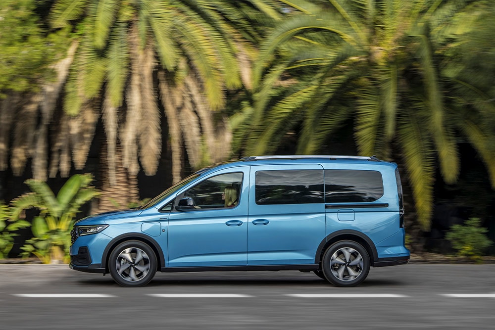 Sininen Ford Tourneo Connect ladattava hybridi pysäköitynä tien laitaan.