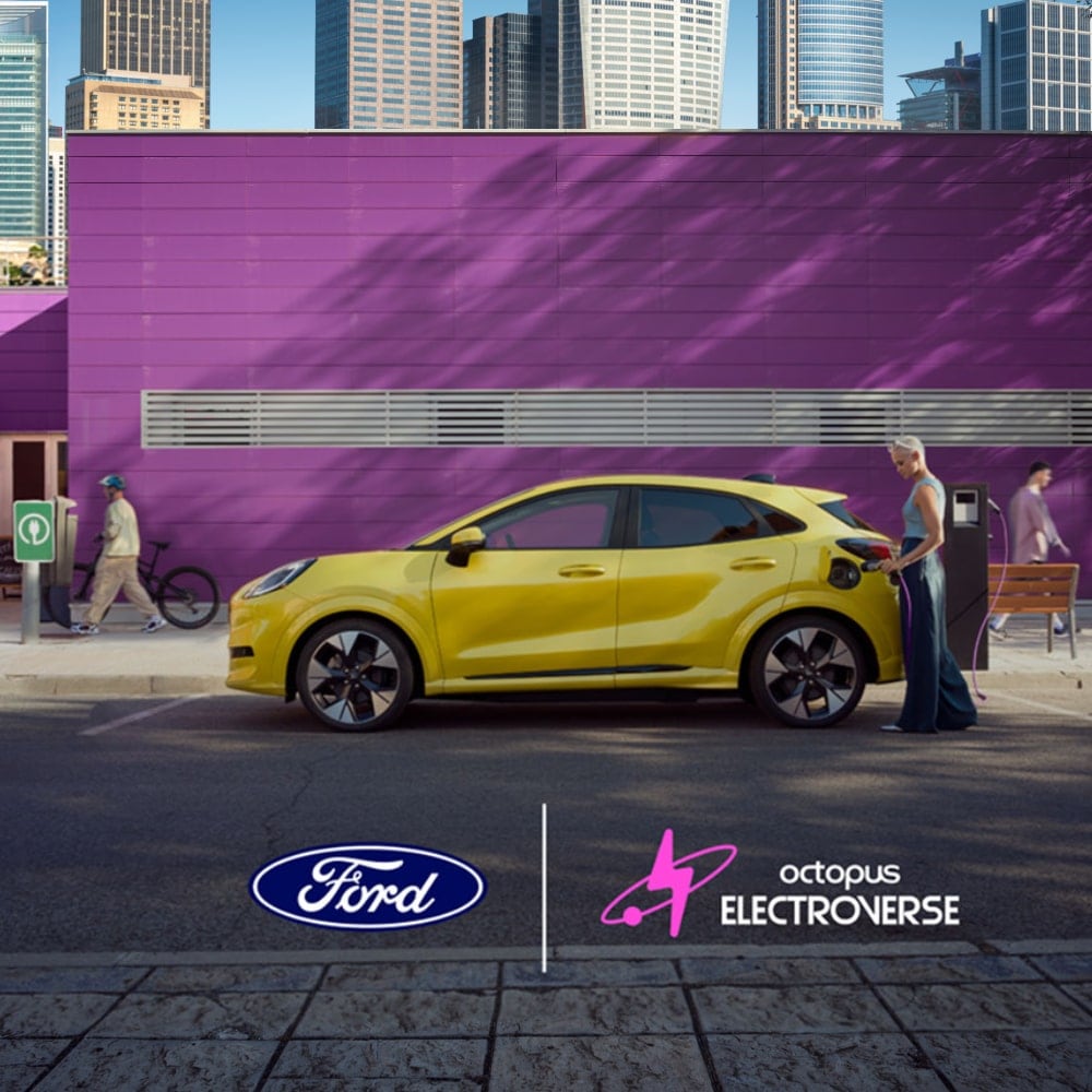 Side view of a yellow electric Ford Puma Gen-E plugged into a public charging point.