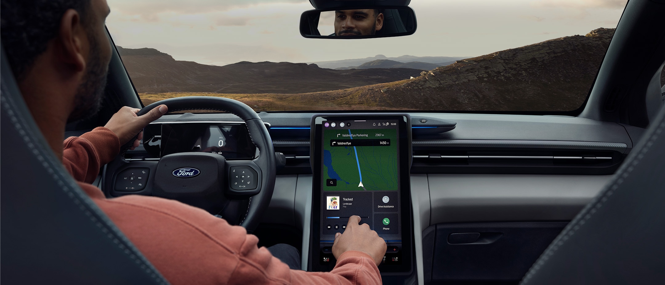 Mies istuu Ford Explorerin kuljettajan paikalla ja käyttää suurta SYNC-kosketusnäyttöä.