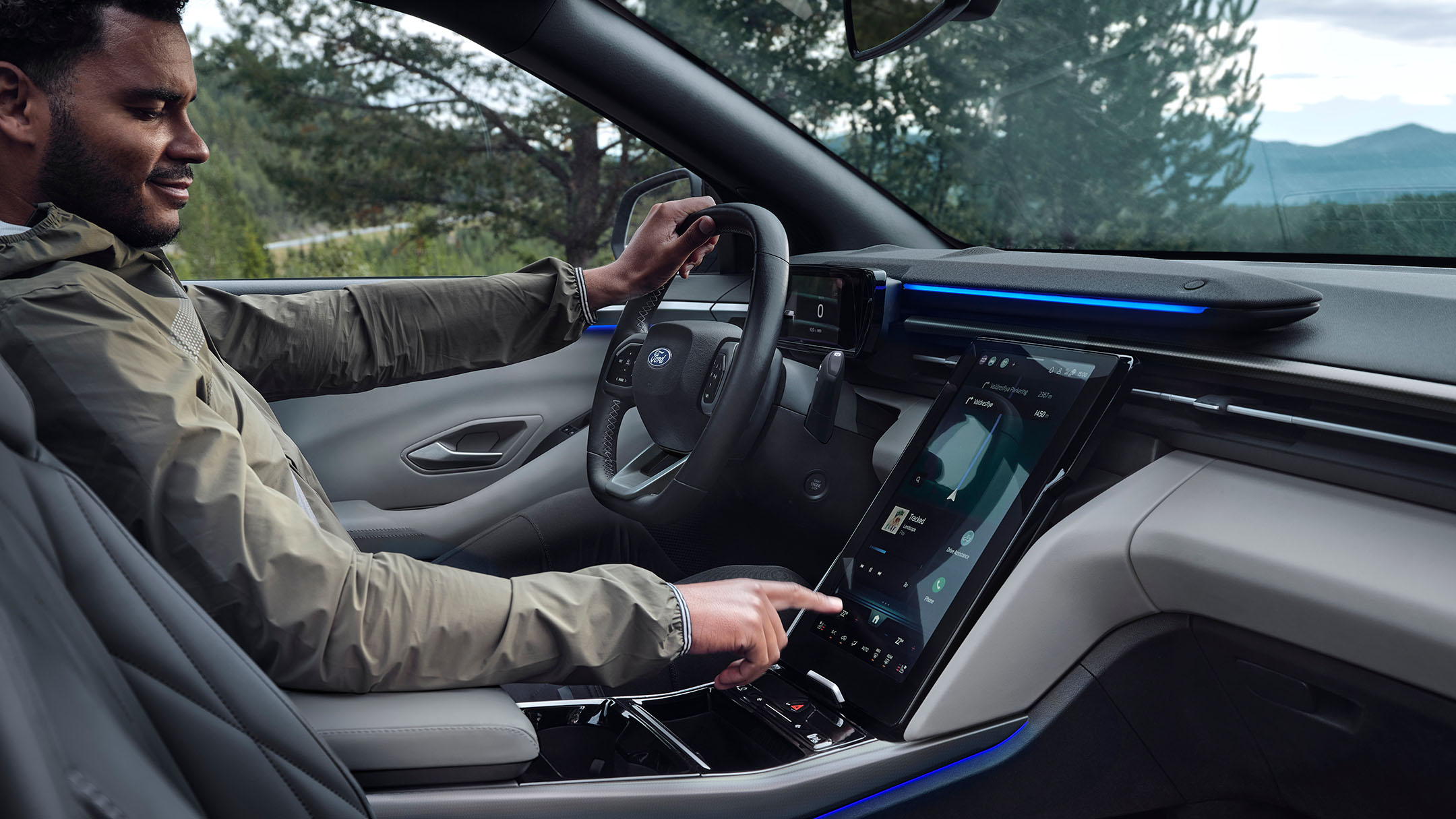 Mies istuu Ford Explorerin kuljettajan paikalla ja käyttää suurta SYNC-kosketusnäyttöä.