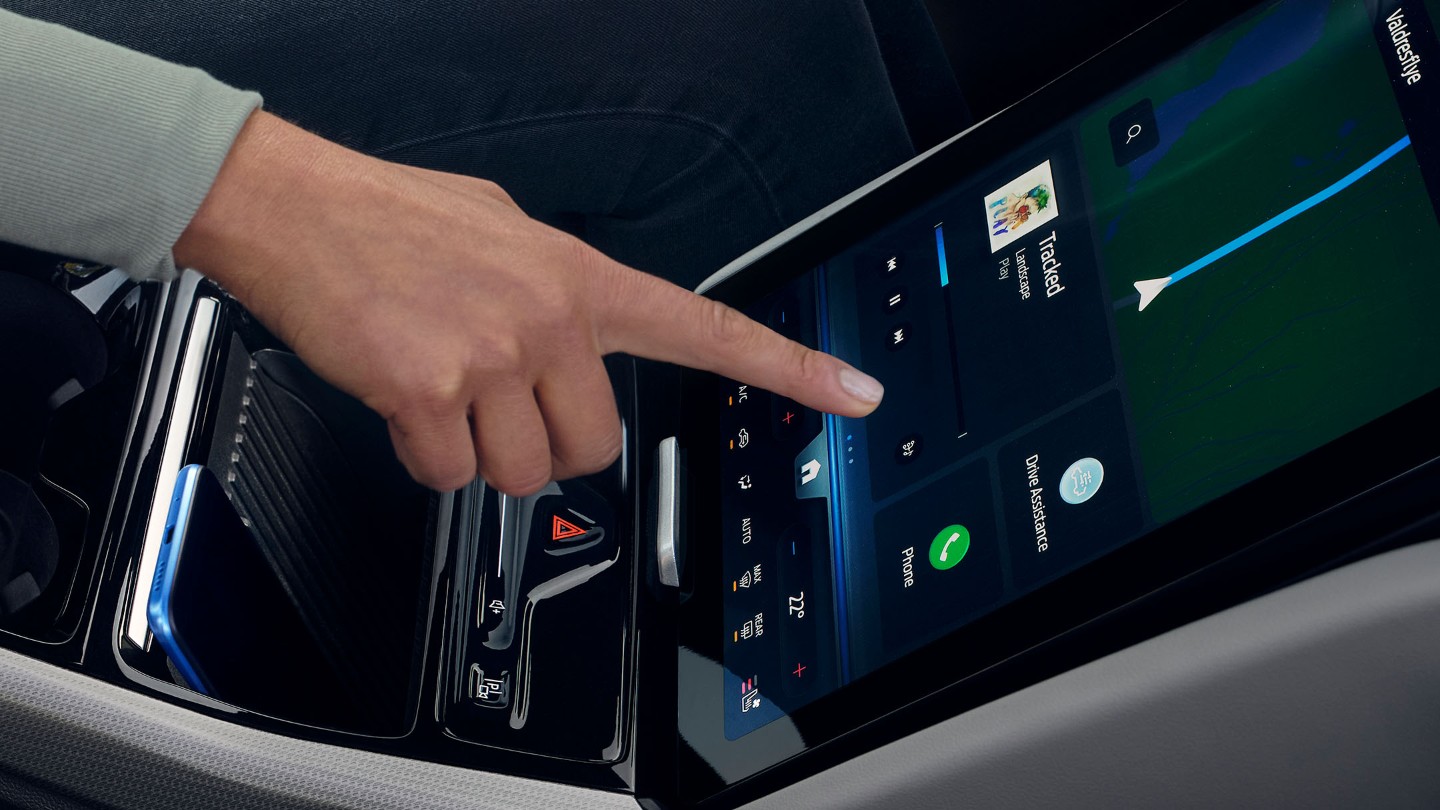 Nainen käyttämässä Ford Explorerin suurta SYNC -kosketusnäyttöä. 