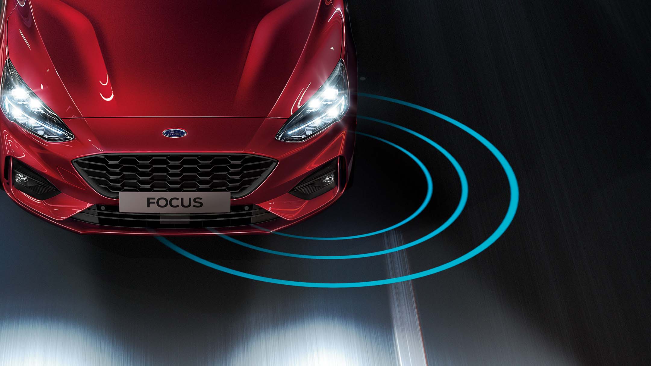 A red Ford Focus on the road, with radiating blue lines indicating a driver-assist feature.