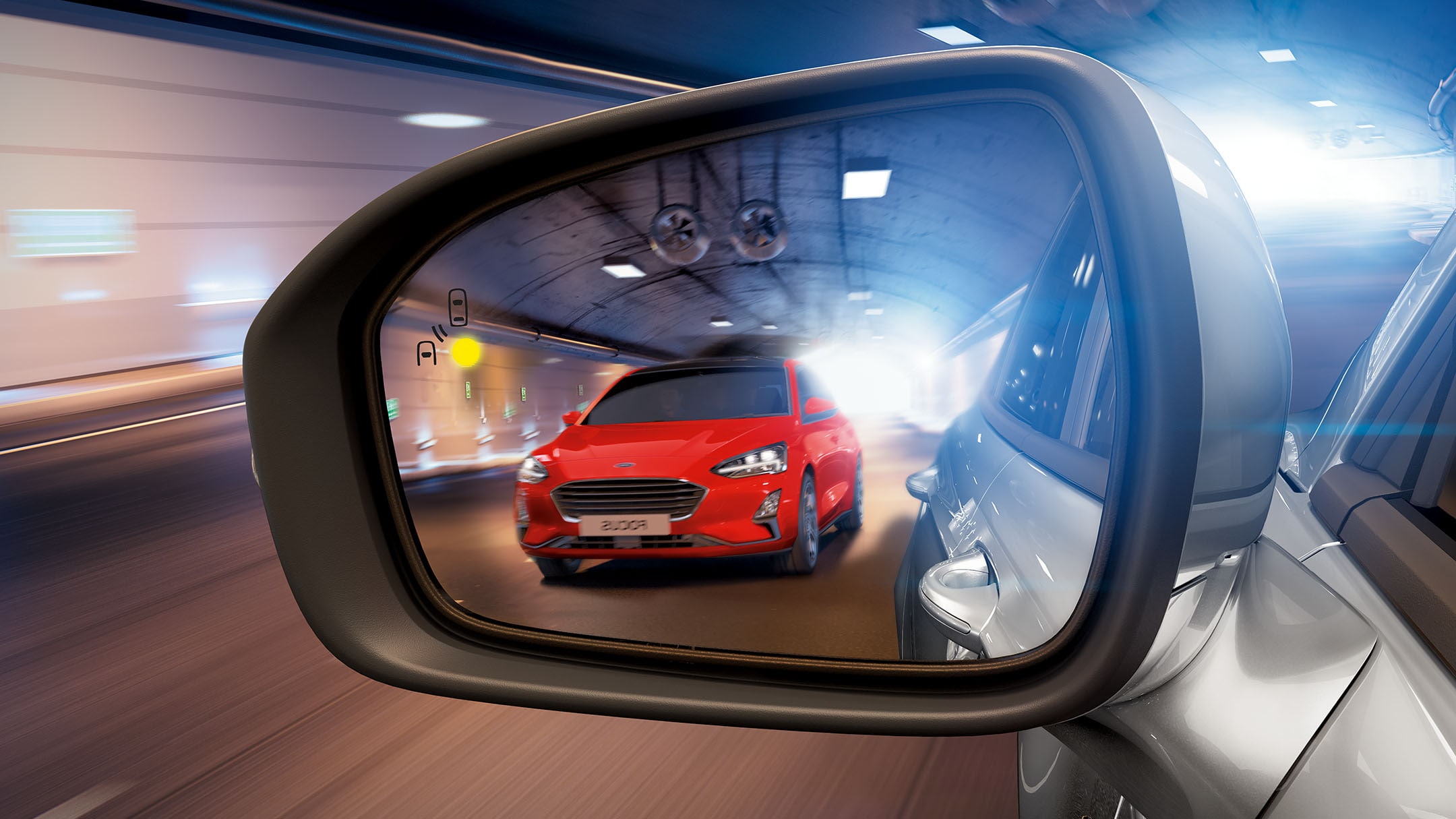 A red Ford Focus is visible in the rearview mirror displaying blind spot information technology.