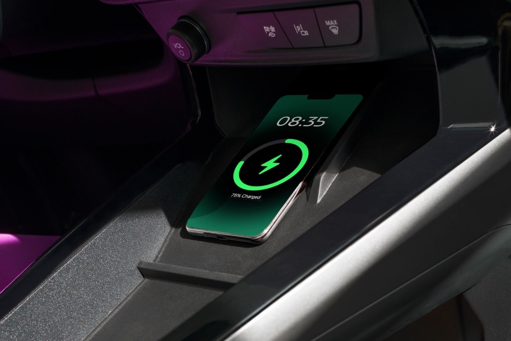 A smartphone charging on the dashboard of a Ford vehicle.
