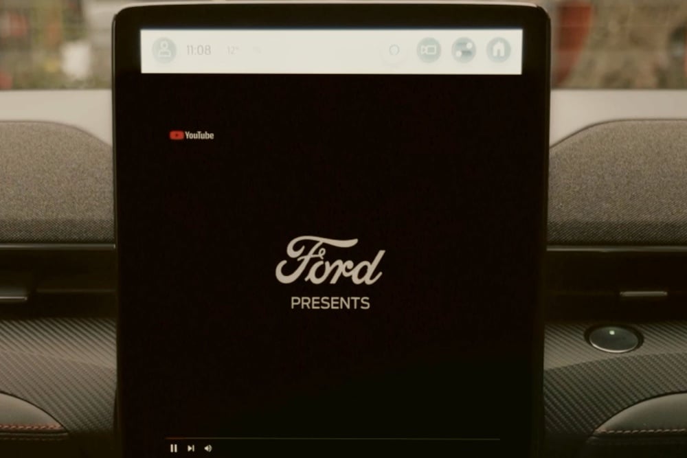 A Ford infotainment screen displaying the Ford logo and "Ford Presents."