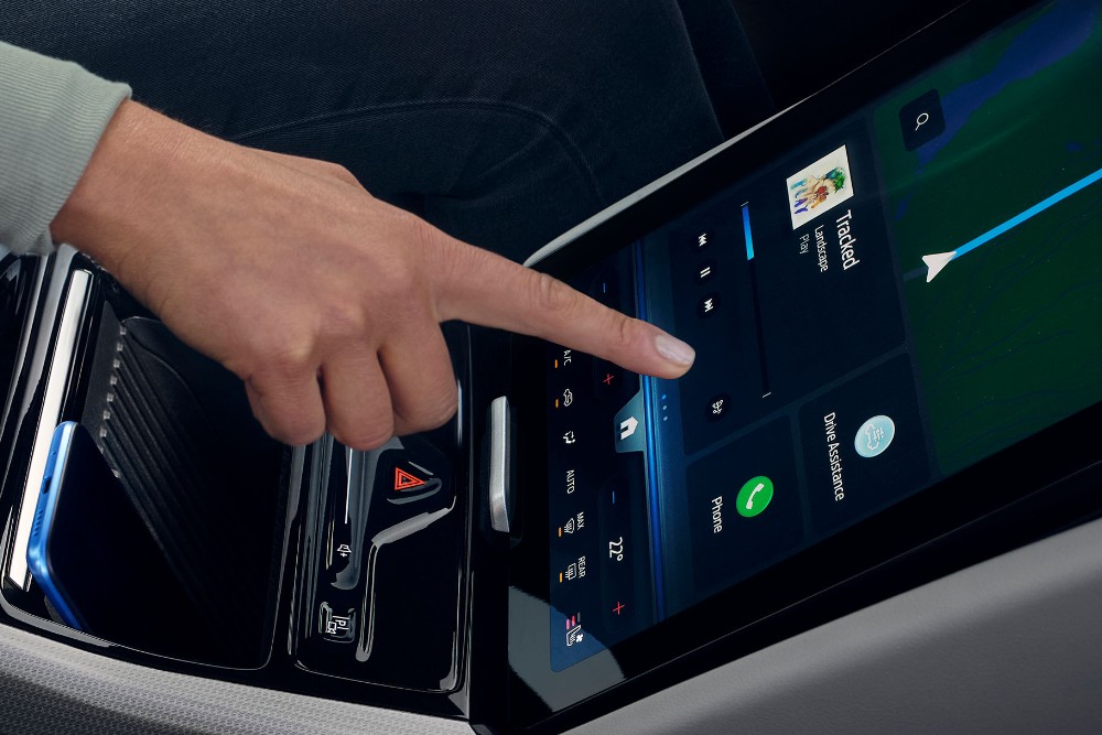 Nainen käyttämässä Ford Explorerin suurta SYNC -kosketusnäyttöä. 