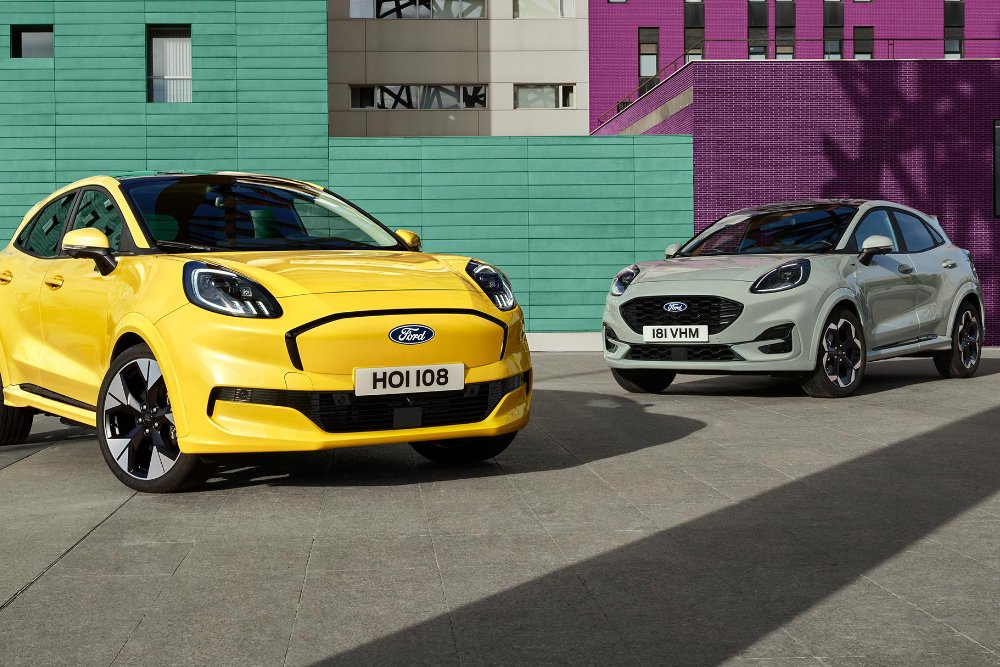 Kaksi Ford Puma -autoa, keltainen ja harmaa, pysäköitynä värikkäiden rakennusten edessä.