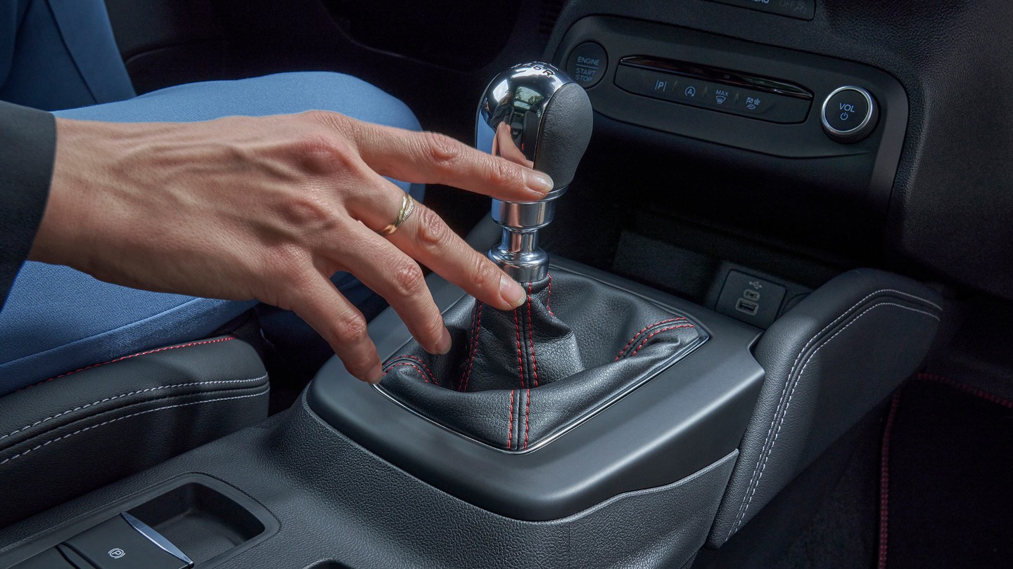 Hand reaching for manual transmission