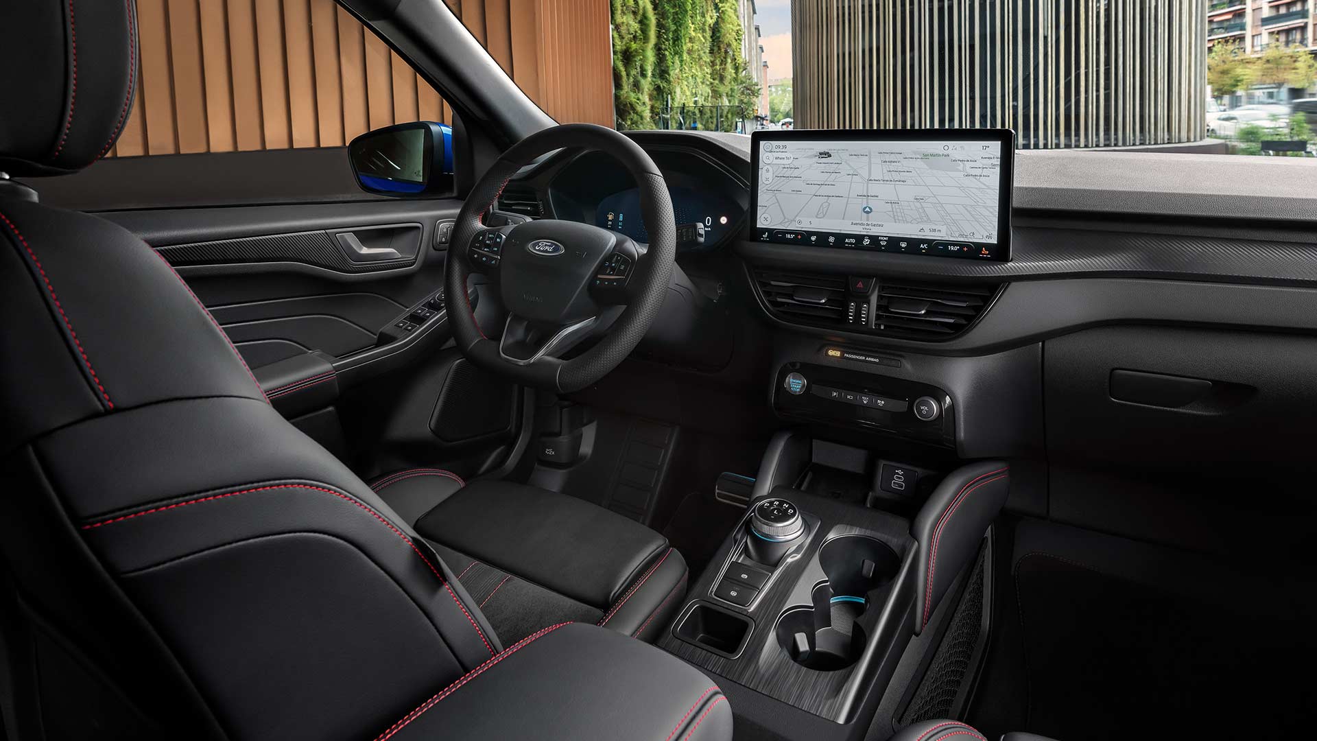 Ford Kugan sisätilat, jossa ohjauspyörän Ford-logo, kookas SYNC® 4 -kosketusnäyttö ja mustat istuimet punaisilla tikkauksilla.