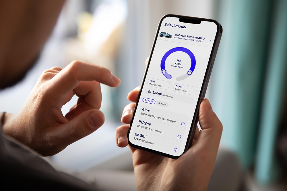 Matkapuhelin, jossa näkyy digitaalisesti Fordin toimintamatka sähköllä sekä latauslaskurityökalu.