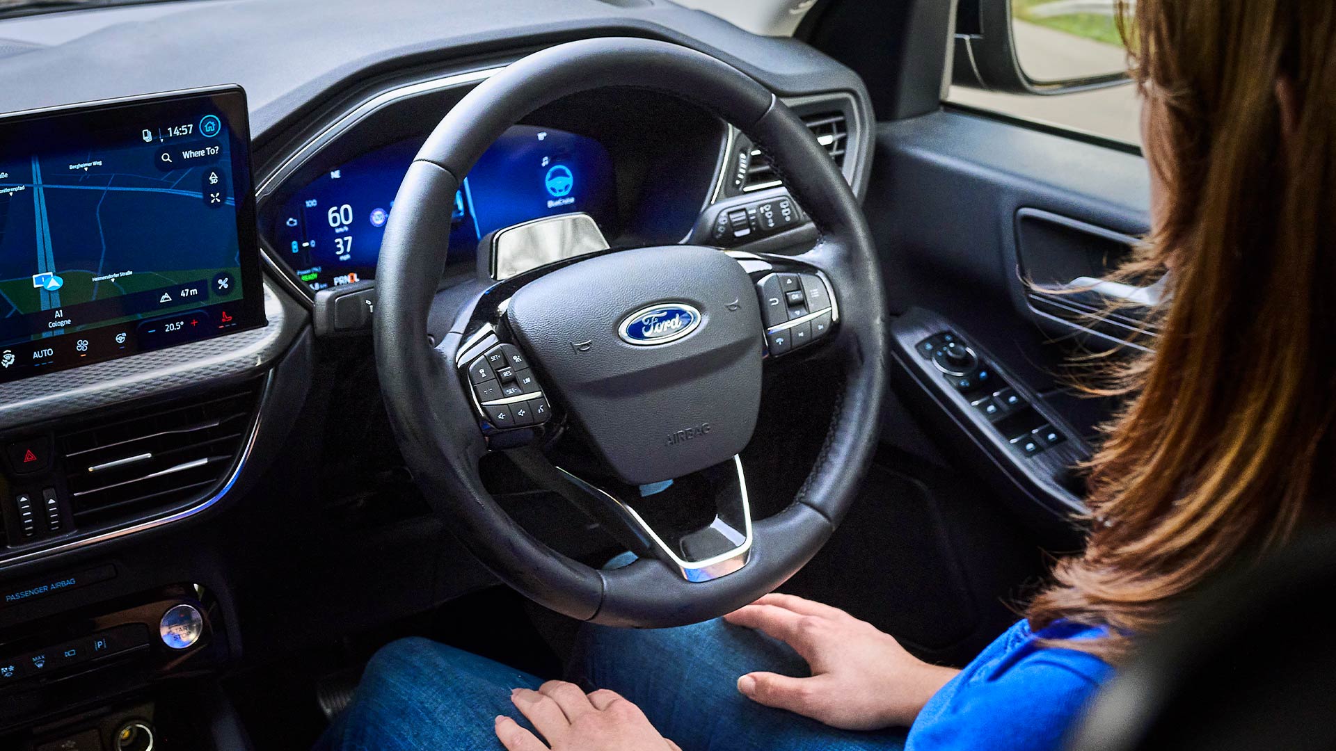 Nainen Ford BlueCruise -ominaisuudella varustetun Kugan kuljettajan istuimella, kädet irti ohjauspyörästä.