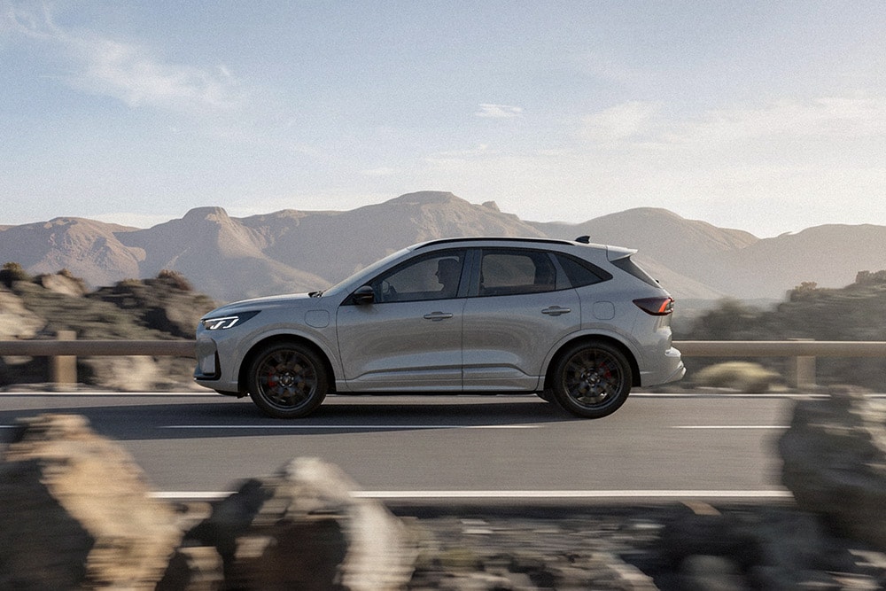 Hopeanvärinen Ford Kuga ajaa pitkin vuoristotietä.