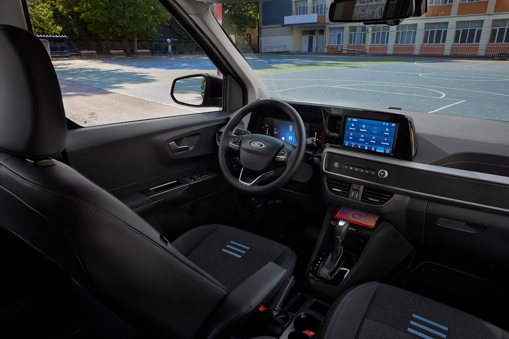 Ford Tourneo Courierin sisätilat, joissa näkyy kojelauta, ohjauspyörä, tietoviihdenäyttö ja etumatkustajan istuin.