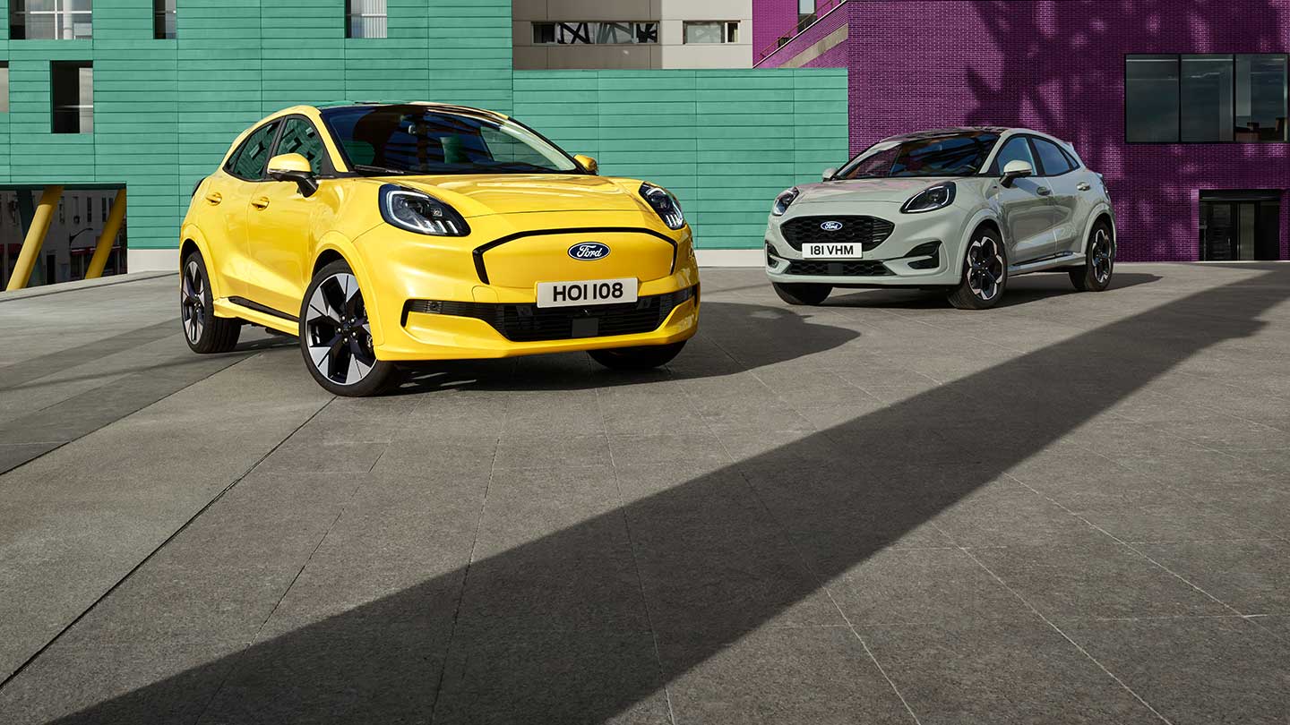 Keltainen Ford Puma Gen-E® -sähköauto pysäköitynä harmaan bensiinikäyttöisen EcoBoost® Ford Puman® viereen. 