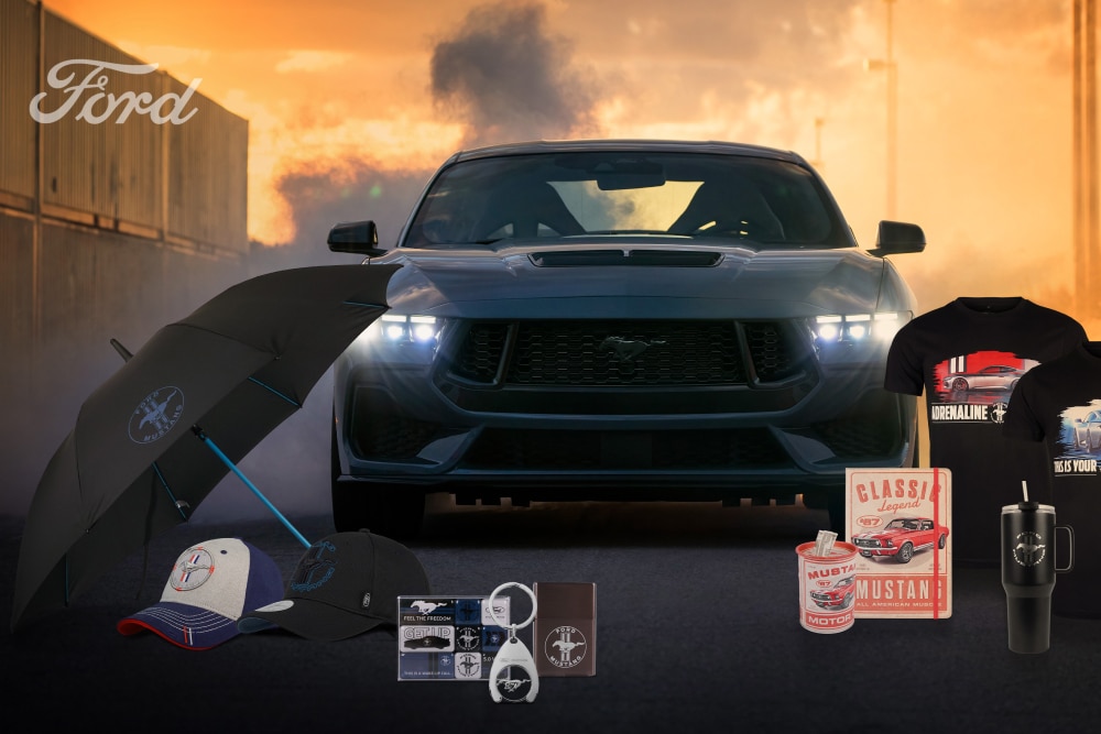 Ford Mustang -mallisto, jossa taustalla harmaa Mustang ja Mustang-aiheisia tuotteita, kuten sateenvarjo, lippalakkeja, mukeja ja t-paitoja.