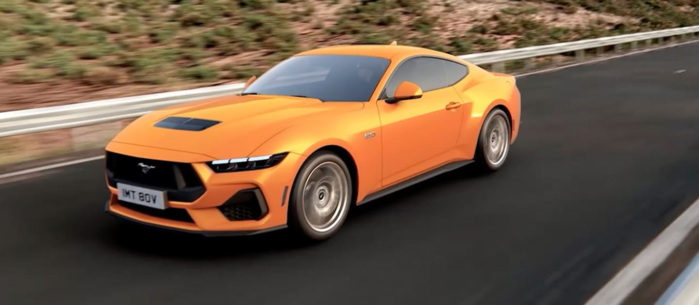 Ford Mustang GT Fastback Orange Fury -värissä ajamassa vuoristotietä