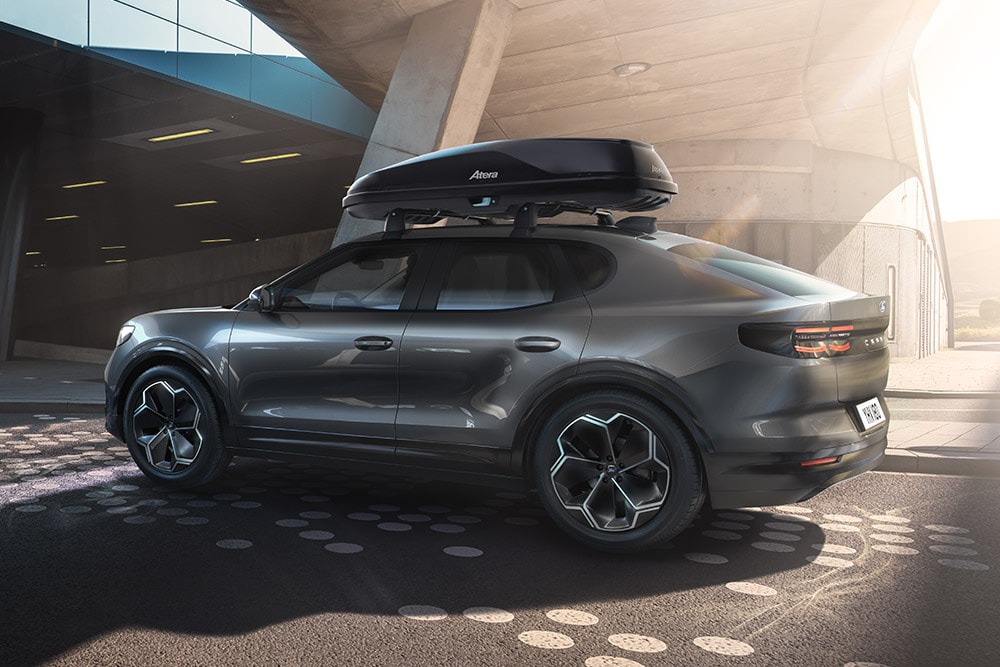 Punaisen Ford Caprin 3/4-sivukuva kattoboksin kanssa, pysäköitynä modernin rakennuksen alle.