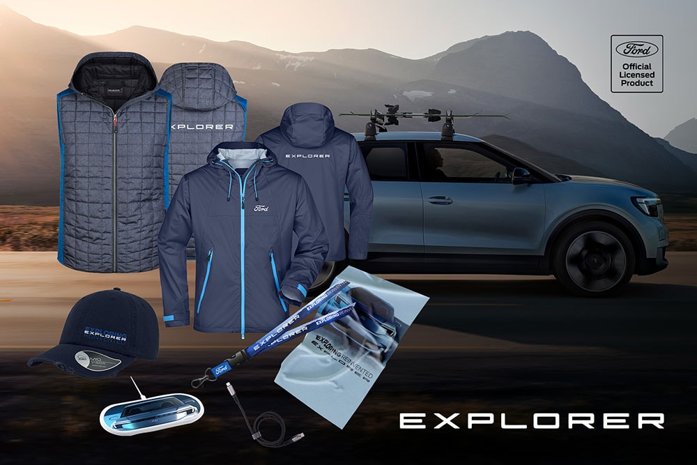 Sinisiä Ford Explorer -tuotteita, kuten takkeja, lippalakki ja muita asusteita, esillä sinisen Ford Explorerin edessä.