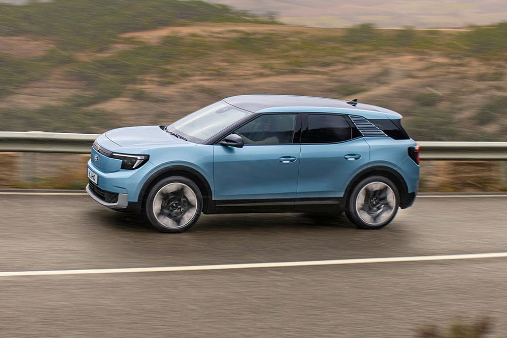 Sininen Ford Explorer ajaa vuoristotietä pitkin, kuvan vasemmassa yläkulmassa on vuoden 2024 viiden tähden Euro NCAP -logo.