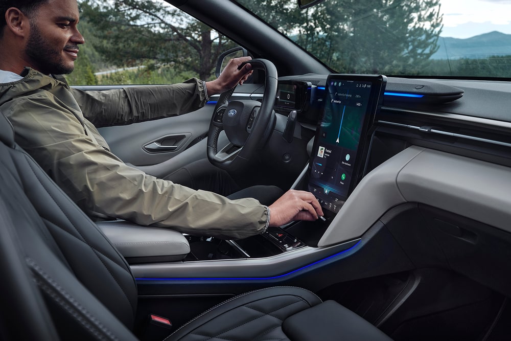 Kuljettaja käyttämässä kosketusnäytöllä varustettua tietoviihdejärjestelmää Ford Explorer -perhekatumaasturissa.