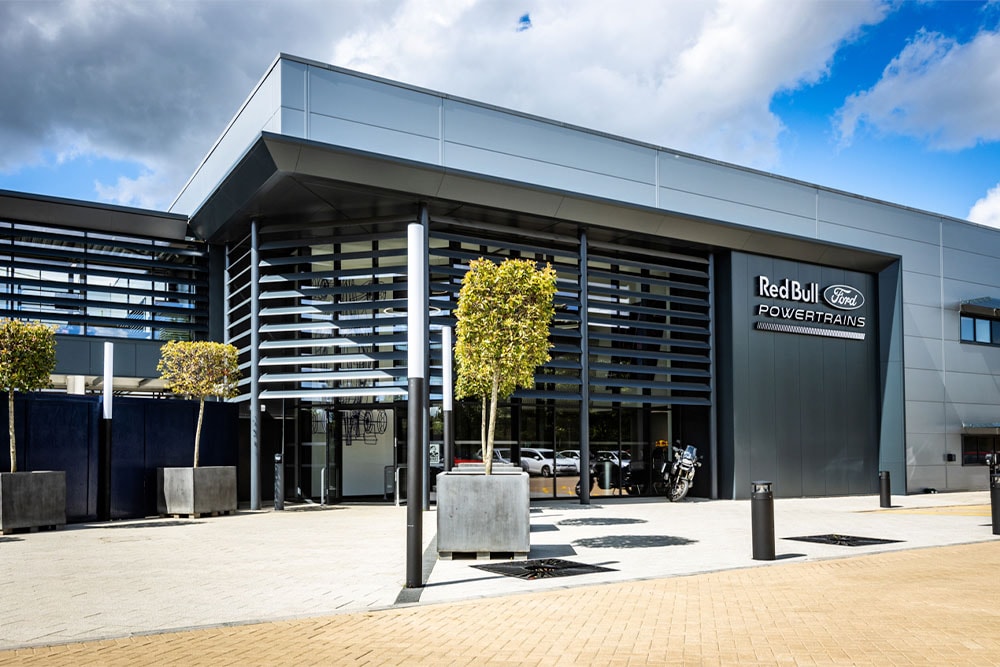 Red Bull Ford Powertrainsin päätoimipaikka – nykyaikainen rakennus, jonka ulkopuolella on yrityksen logo