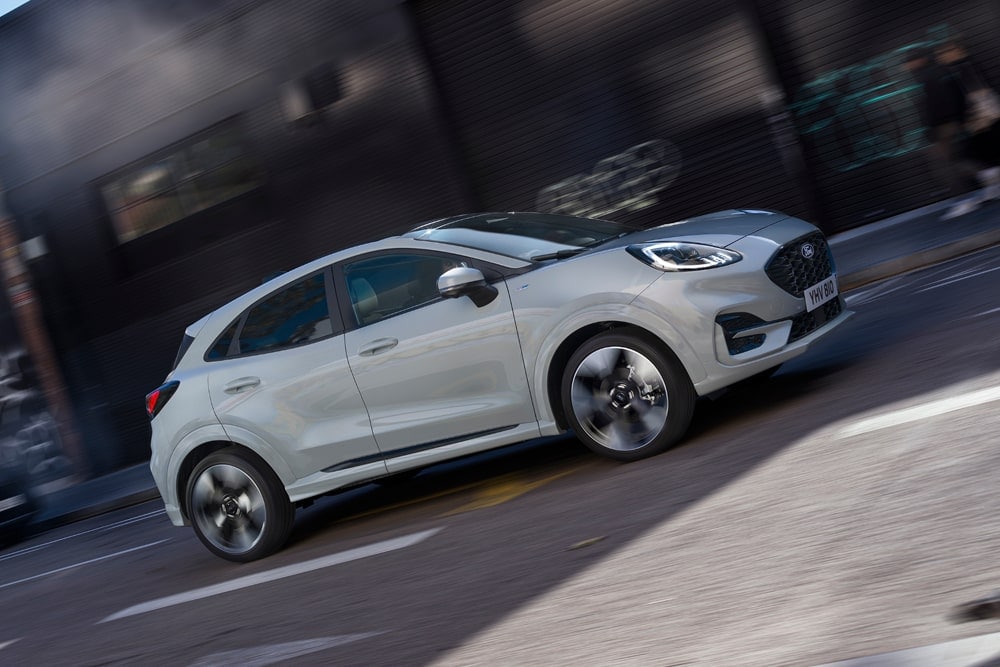 Hopeanvärinen Ford Puma Fordin pienten autojen mallistosta ajamassa kaupungilla.