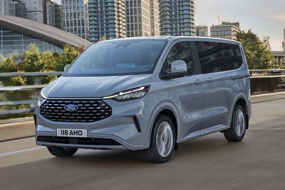 Hopeanvärinen Ford Tourneo Custom ajamassa kaupungilla.