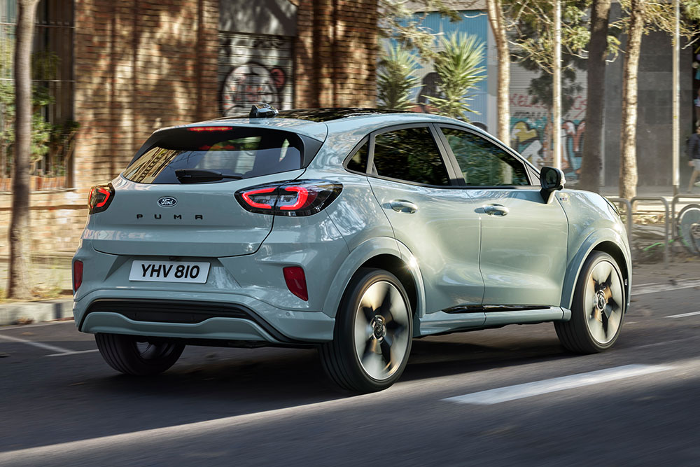 Harmaa Ford Puma takaa päin kuvattuna ajamassa kaupungin kadulla ihmisten ja rakennusten keskellä.