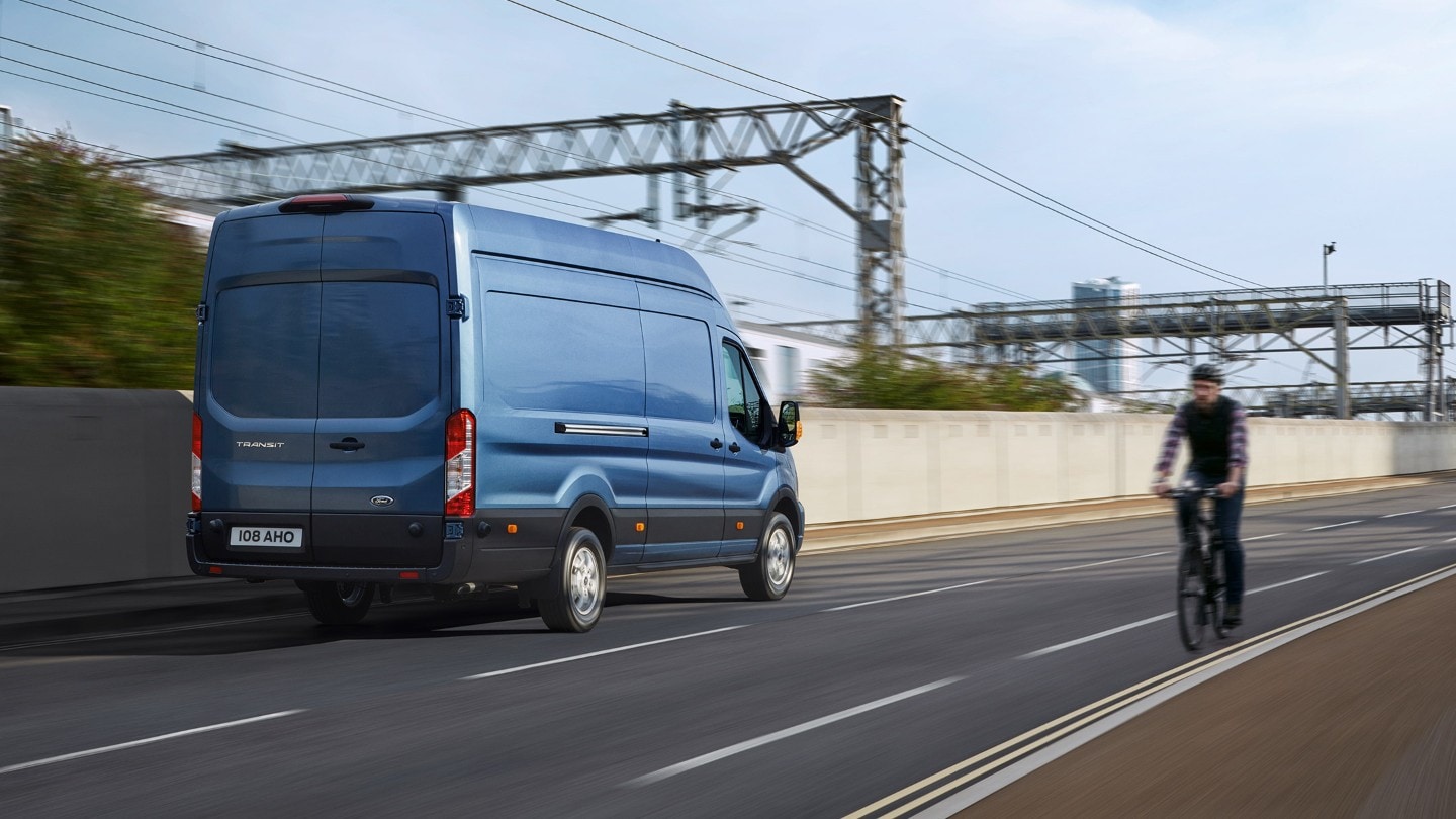 New Blue Transit Van rear view driving on road