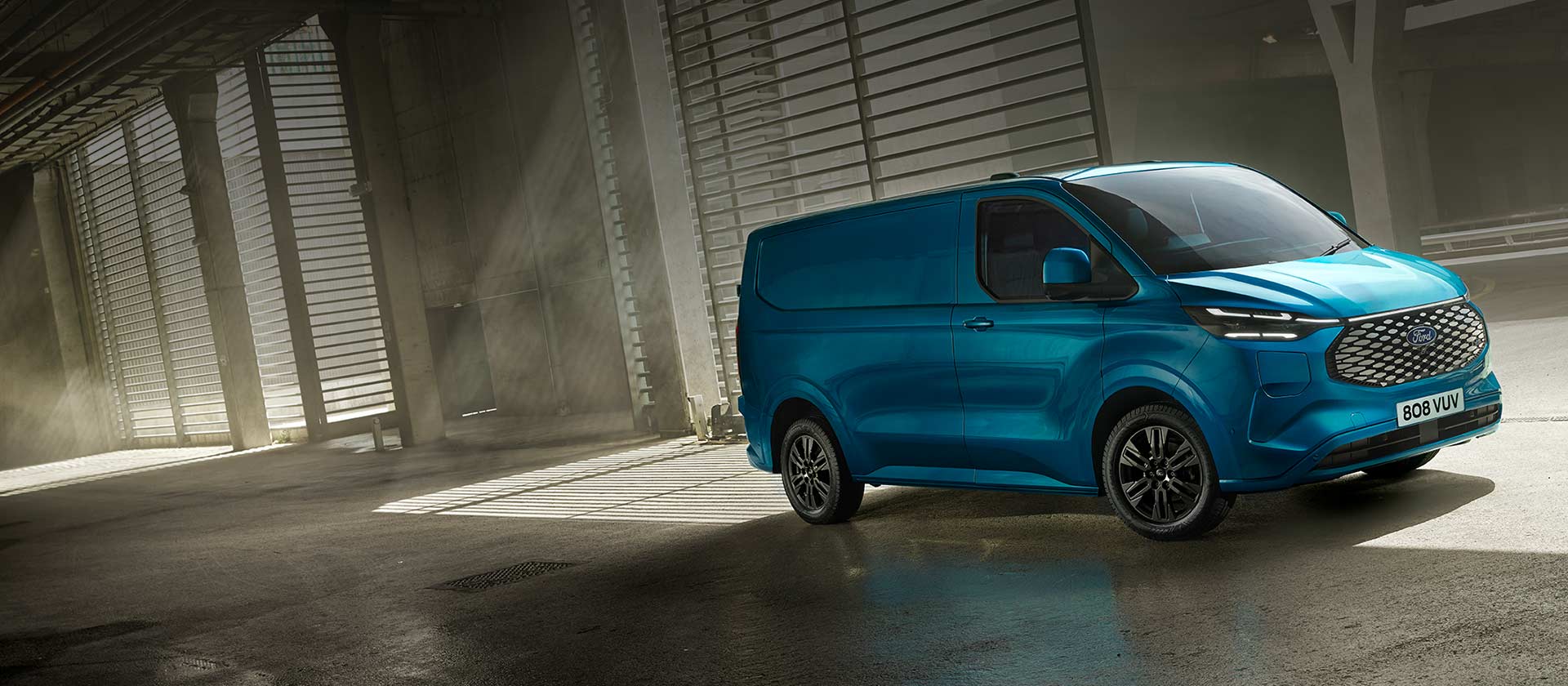 Sininen täyssähköinen Ford E-Transit Custom -pakettiauto ajossa.