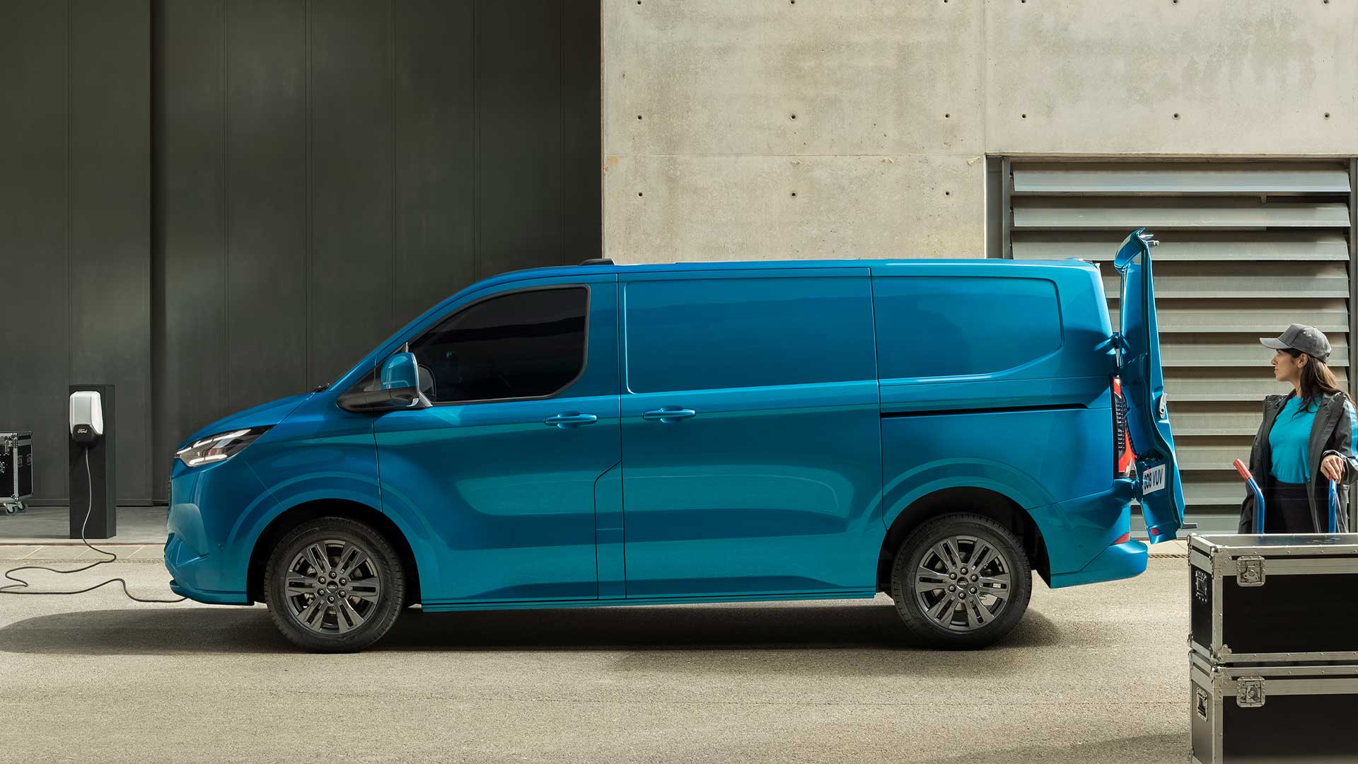 Sininen täyssähköinen Ford E-Transit Custom -pakettiauto latauksessa.
