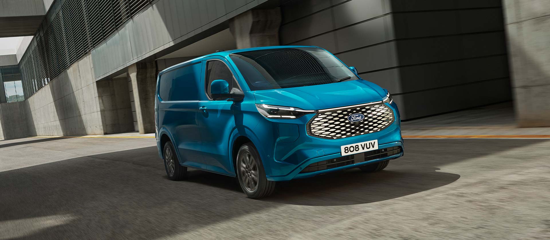 Sininen täyssähköinen Ford E-Transit Custom -pakettiauto sivusta kuvattuna.
