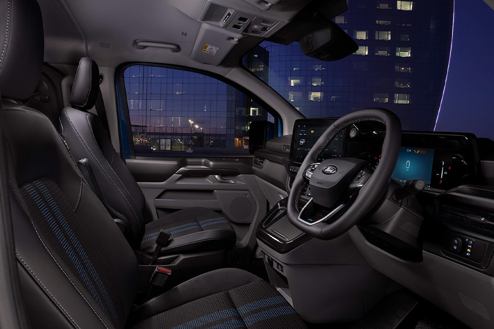 Täyssähköisen Ford E-Transit Custom -pakettiauton sisätilat; kuljettajan ja matkustajan istuimet.