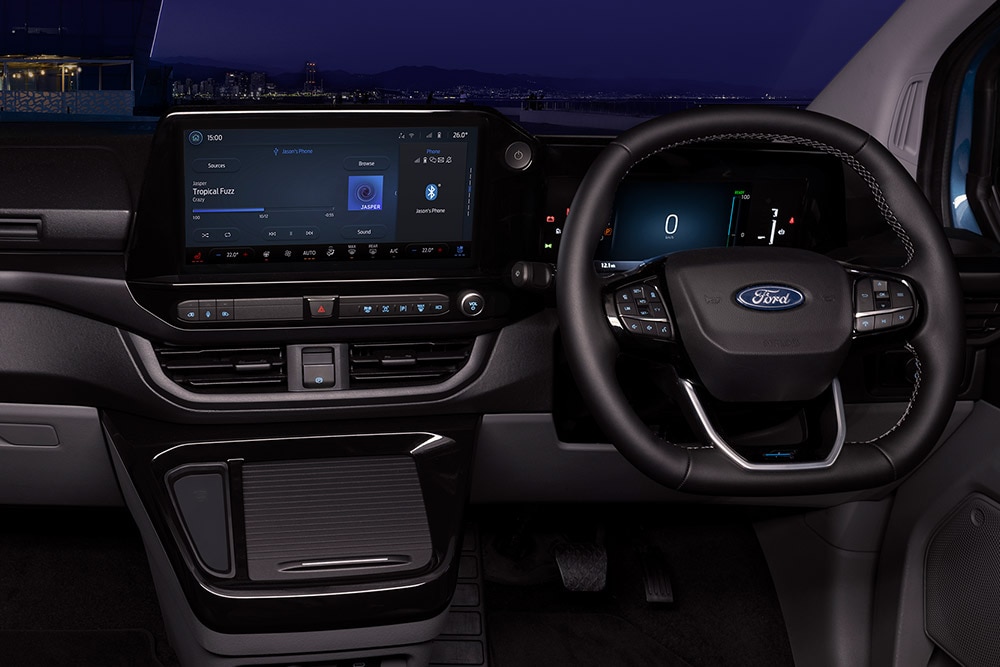 Täyssähköisen Ford E-Transit Custom -pakettiauton sisätilat, joissa näkyy kuljettajan ja matkustajan istuimet.