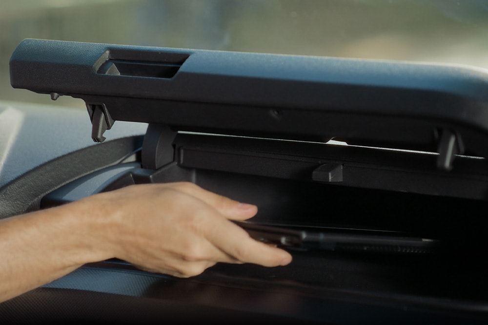 Käsi avaamassa täyssähköisen Ford E-Transit Custom -pakettiauton säilytyslokeroa.