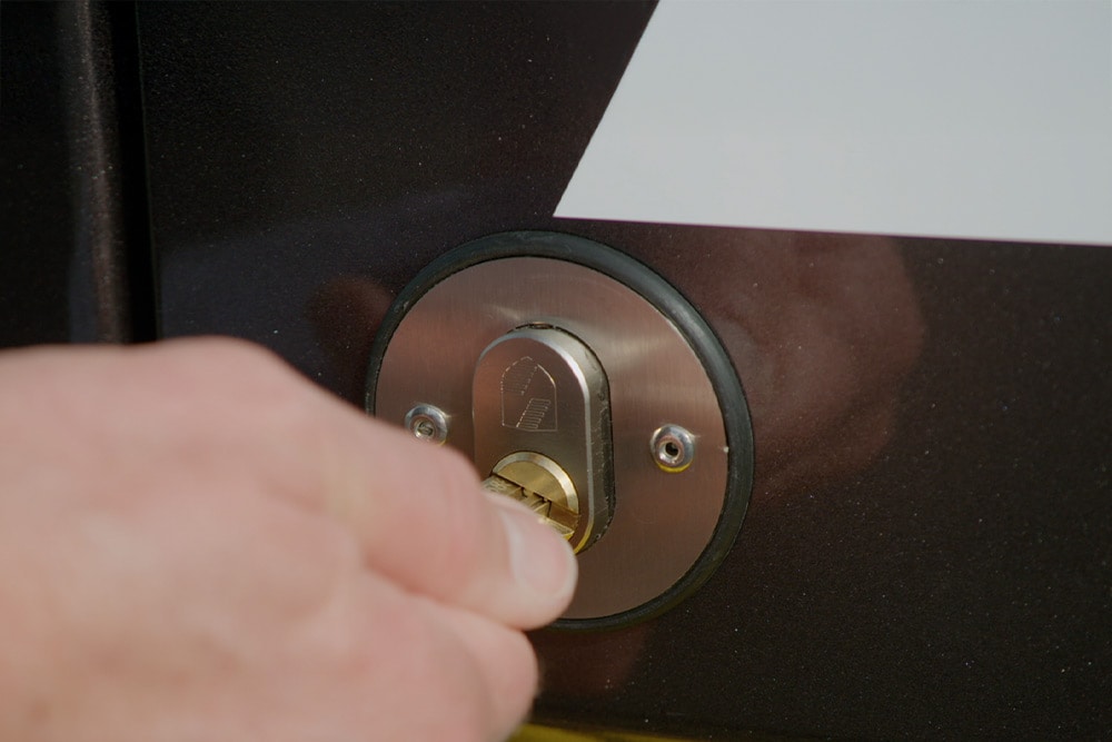 Käsi lukitsemassa pakettiauton ovea avaimella.