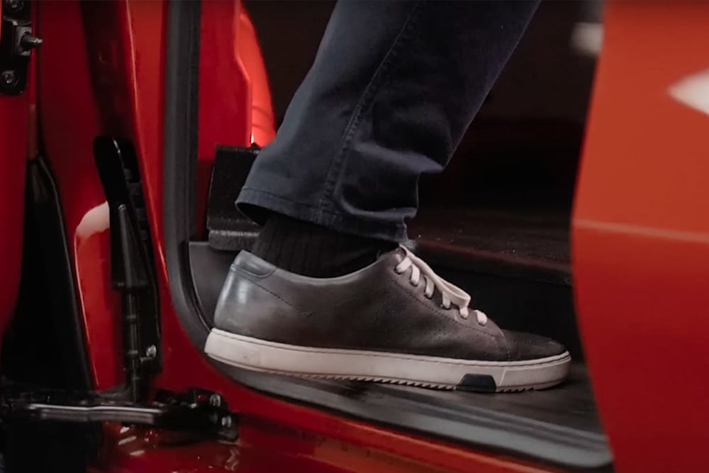 Jalka astumassa sähköiseen Ford E-Transit Custom -pakettiautoon.