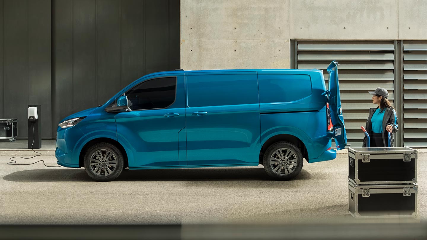 Sininen sähköinen Ford E-Transit Custom -pakettiauto latautumassa.