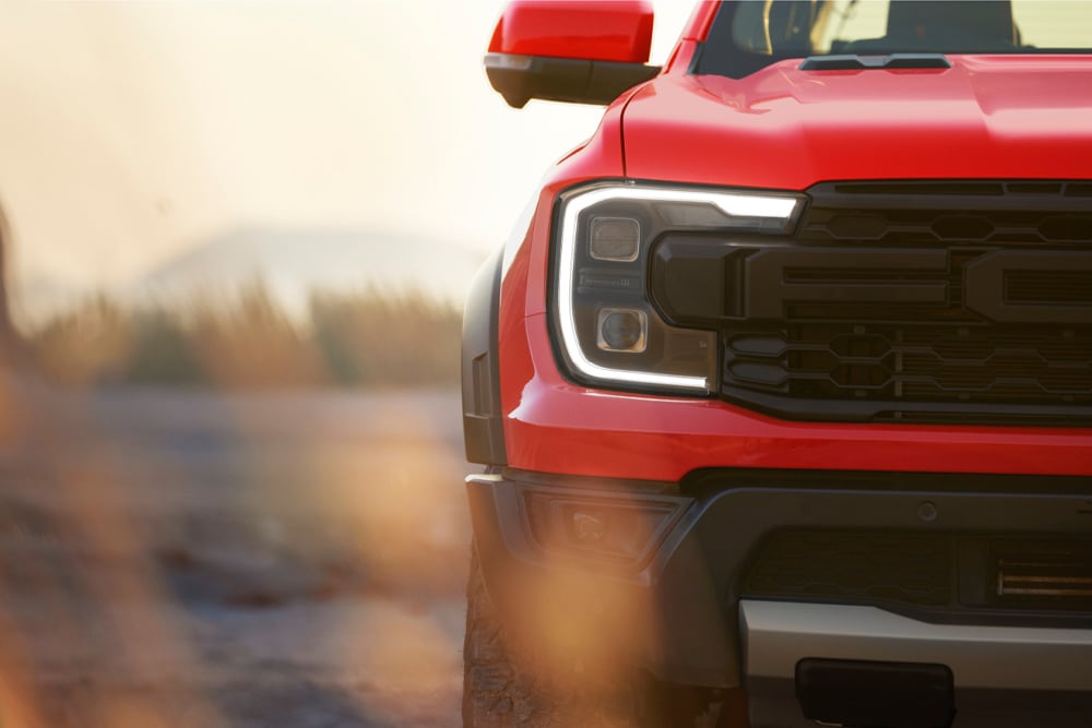 Lähikuvassa näkyy punaisen Ford Ranger Raptorin etusäleikkö.