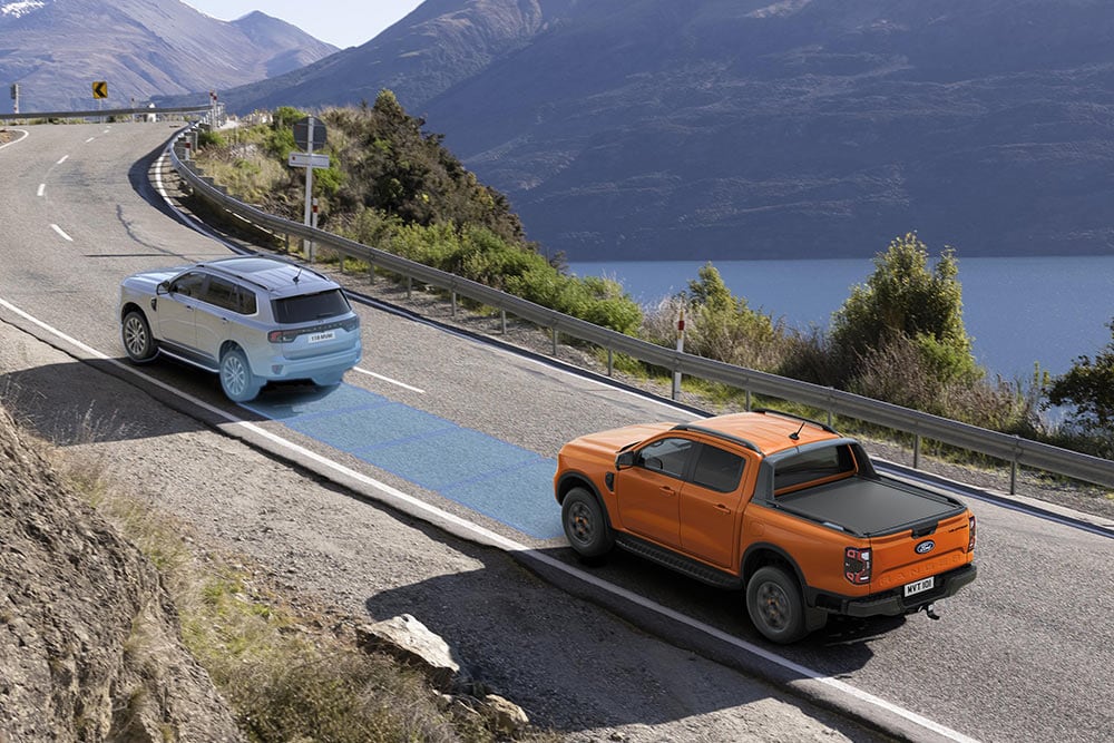 Keltainen Ford Ranger Raptor ajaa vuoristotietä pitkin.