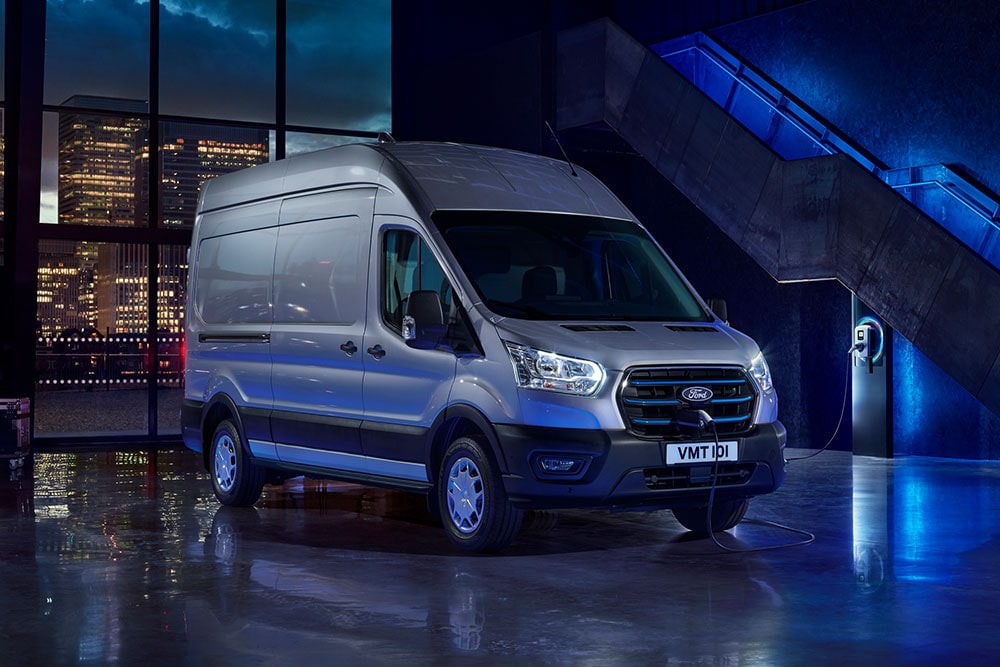 Ford E-Transit pysäköitynä latauspisteen lähelle.