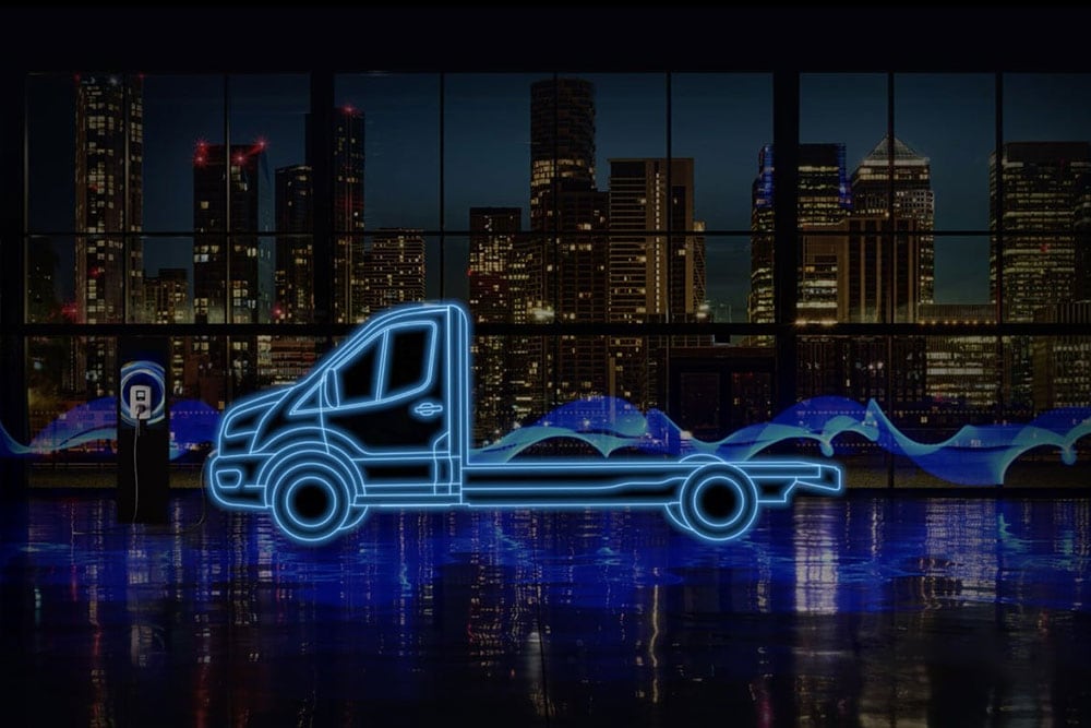 Ford E-Transit Chassis Cabin ja latausaseman neonsiniset ääriviivat kaupungin siluettia vasten.