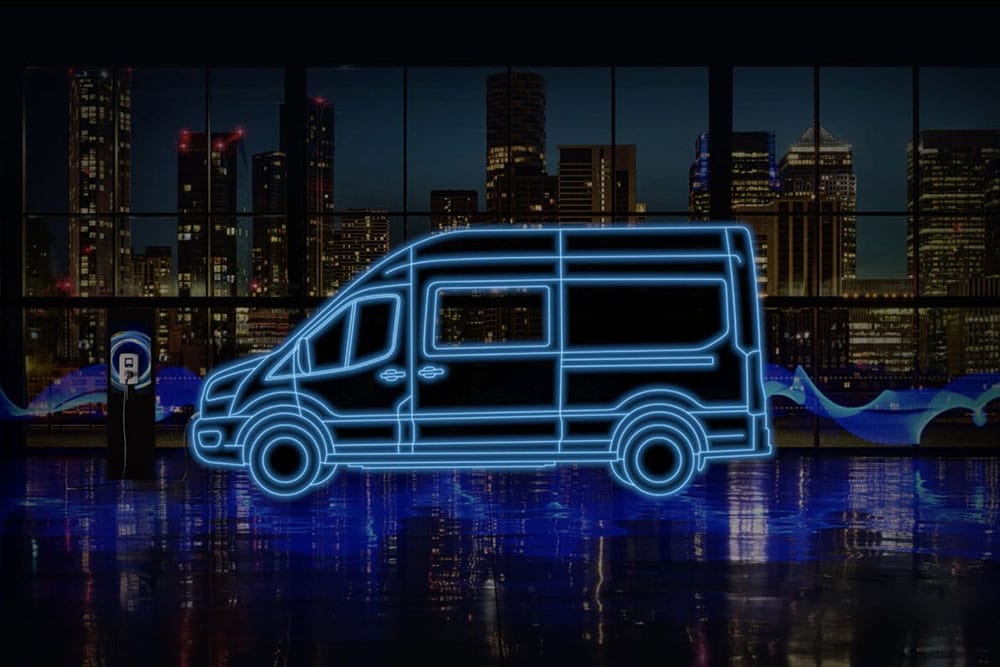 Ford E-Transit -jatko-ohjaamopakettiauton ja latausaseman neonsiniset ääriviivat kaupungin siluettia vasten.