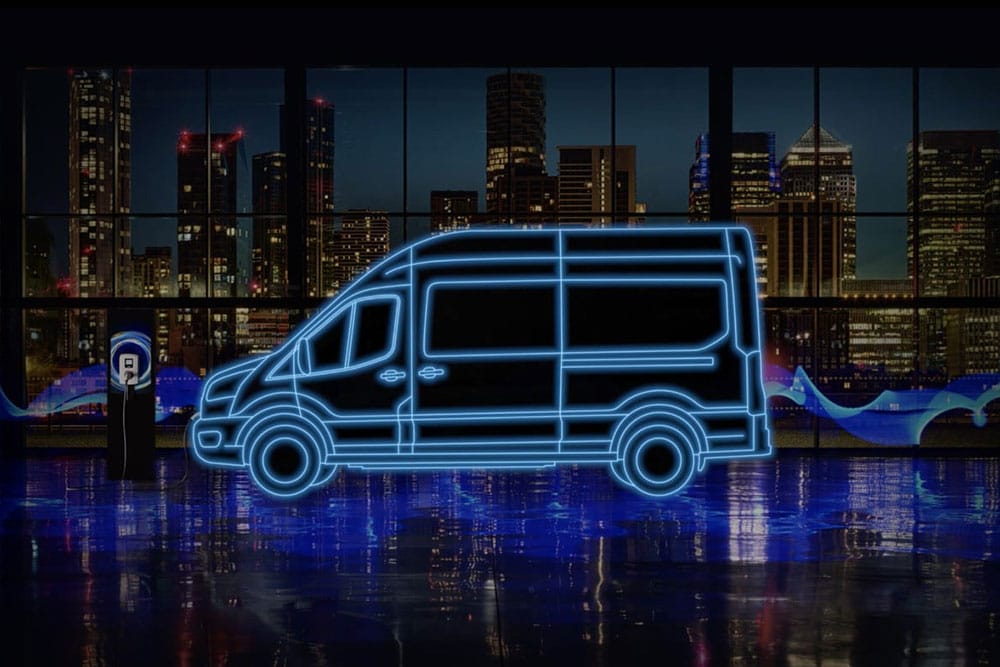 Ford E-Transit -sähköpakettiauton ja latausaseman neonsiniset ääriviivat kaupungin siluettia vasten.