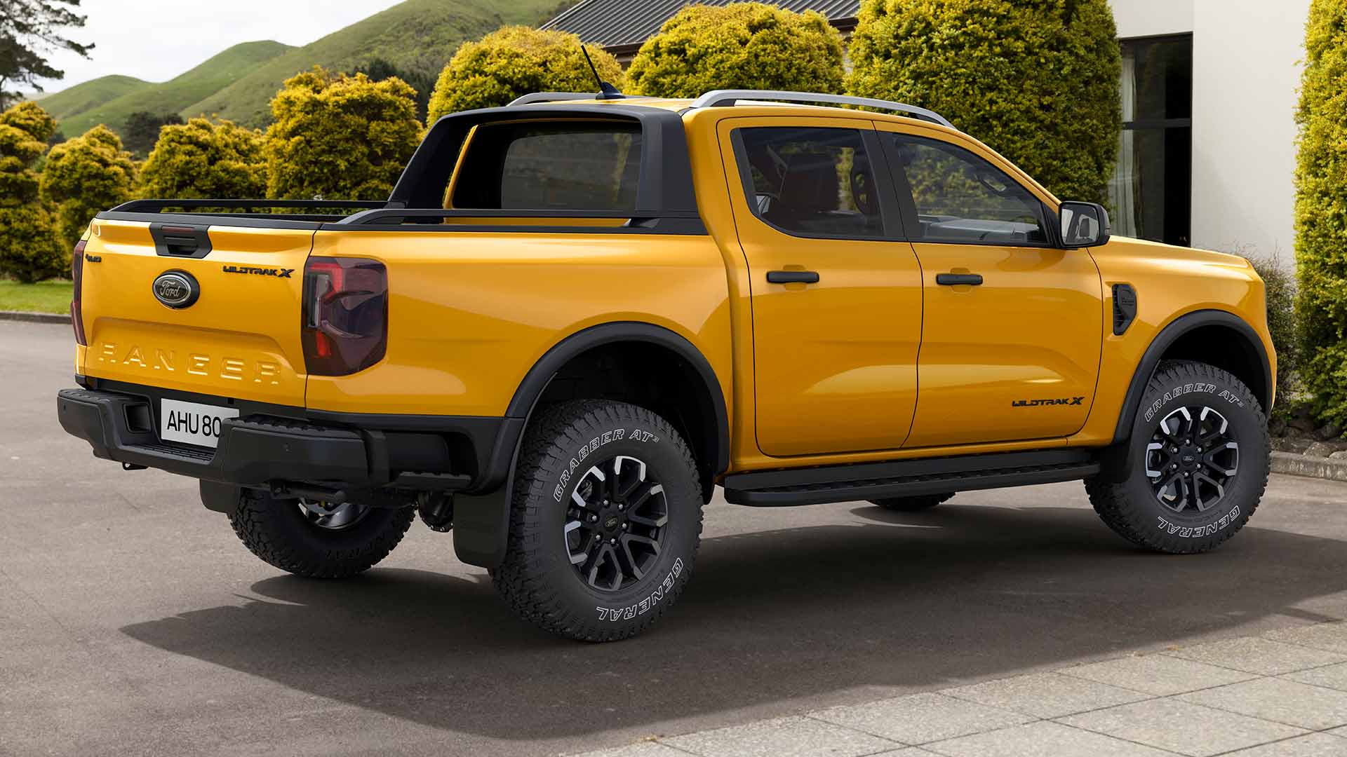 Keltainen 5-paikkainen Ford Ranger Double Cab pysäköitynä päällystetylle pihatielle.