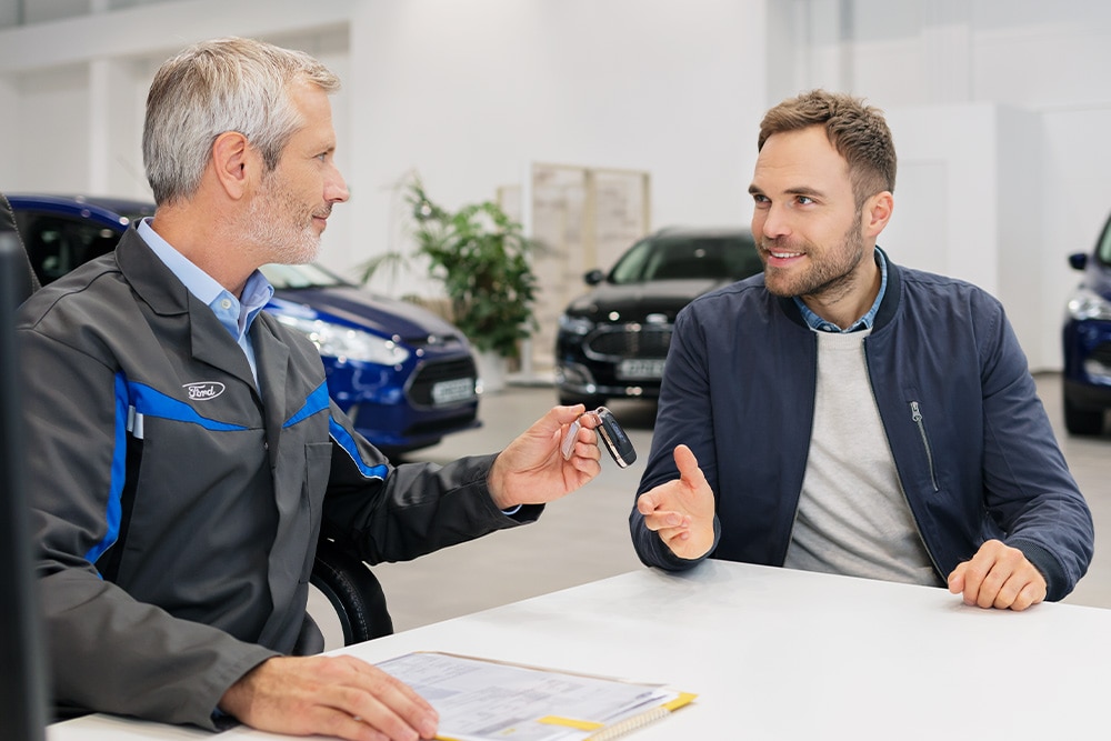 Kaksi henkilöä keskustelemassa Ford-liikkeessä.